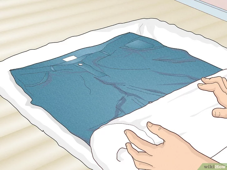 Vắt quần áo trong một chiếc khăn tắm để hút nước